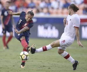 El jugador tico David Ramirez dispara el balón ante la marca de Samuel Piette (Foto: Agencia AFP)