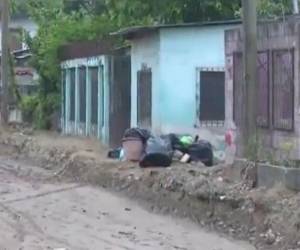 El cadáver estaba al lado de la basura en una de las calles de la popular colonia.