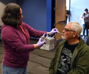 La voluntaria de la Cruz Roja Americana Jennifer Kilroy toma la temperatura de Conrad Lochner. Foto AFP