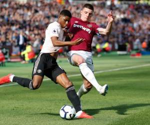 El delantero del Manchester United Marcus Rashford (izq.) Acude al defensor irlandés del West Ham United Declan Rice (R) en el partido de fútbol de la Premier League inglesa entre el West Ham United y el Manchester United en el London Stadium, en el este de Londres.