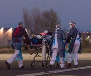 El personal médico transporta a un paciente infectado con el nuevo coronavirus (Covid-19) en el aeropuerto de Aulnat. Foto: Agencia AFP.