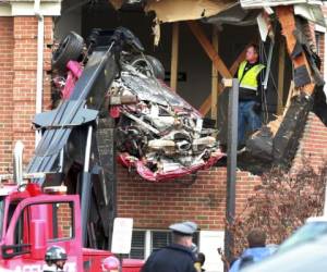 Los restos de un Porsche son retirados de un edificio después de que el vehí­culo se elevó por el aire y se metió al segundo piso. Foto: AP.