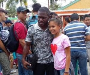 Milton Tyson Núñez se toma una fotografía con una niña hondureña que va en la caravana de migrantes.
