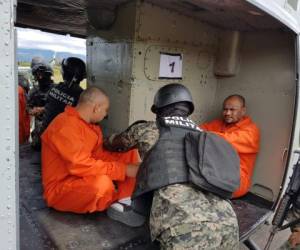 Miembros de la Policía Militar acomodan a los criminales en los helicópteros de la Fuerza Aérea Hondureña (FAH).