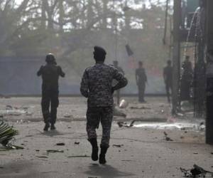 Las fuerzas de seguridad de Sri Lanka se acercan al sitio después de que un vehículo estacionado cerca del santuario de San Antonio explotó en Colombo, Sri Lanka, el lunes 22 de abril de 2019. (Foto AP / Eranga Jayawardena)