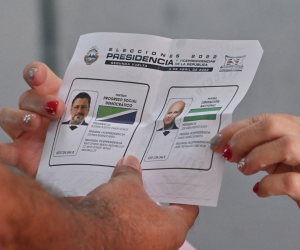 Un delegado electoral le muestra a un hombre una boleta sin marcar en un colegio electoral en San José, el 3 de abril de 2022, durante la segunda vuelta de las elecciones presidenciales.