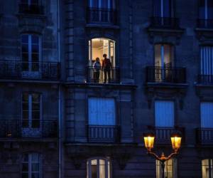 Personas encienden velas en la isla Saint-Louis en París, en el noveno día de un encierro destinado a frenar la propagación del Covid-19.