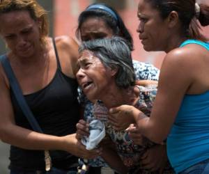 Los familiares lloran después de enterarse de que sus seres queridos murieron en un incendio de rápido movimiento un día antes que azotó una estación de policía donde se mantenía a los prisioneros en celdas abarrotadas en Valencia, Venezuela. Foto AP