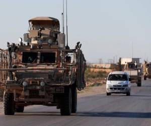 En imagen de archivo del sábado 31 de marzo de 2018, un convoy de las fuerzas militares de Estados Unidos viaja por una carretera rumbo al frente con combatientes respaldados por Turquía, en Manbij, Siria.