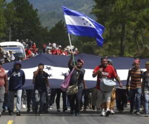 Enarbolando la Bandera Nacional de Honduras, la caravana de migrantes hondureños ya está en Chiquimula, Guatemala, tras tres días de caminata hacia Estados Unidos. (Foto: AP)