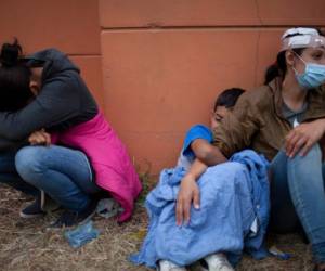 Mujeres de una caravana de migrantes hondureños que resultaron heridas cuando intentaban llegar a la frontera estadounidense lloran junto a una autopista tras chocar con policías y soldados guatemaltecos en Vado Hondo, Guatemala. (AP Foto/Sandra Sebastian, Archivo)