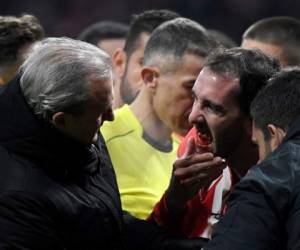 El jugador uruguayo Diego Godín durante la asistencia médica tras el fuerte golpe por el que perdió tres dientes. (AFP)