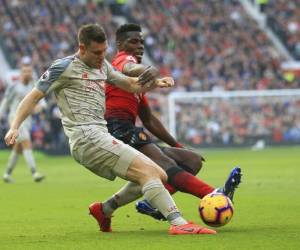James Milner (izquierda), del Liverpool, y Paul Pogba, del Manchester United, disputan un balón durante un encuentro de la Liga Premier inglesa. (Foto: AP)