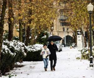 Una pareja camina en Jerusalén después de una nevada nocturna el 27 de enero de 2022. Foto: AFP