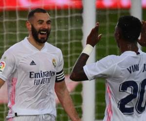 El delantero francés del Real Madrid Karim Benzema, celebra con el delantero brasileño Vinicius Junior, tras marcar un gol durante el partido de fútbol en el estadio Alfredo di Stefano de Valdebebas. FOTO: AFP