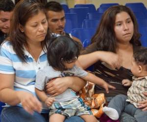 Madres y niños esperan ser asistidos por voluntarios en un centro humanitario en la ciudad fronteriza de McAllen, Texas. (AFP)