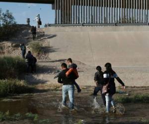 Familias de migrantes cruzan el río Bravo para ingresar ilegalmente a Estados Unidos, donde se entregaron a las autoridades y solicitaron asilo, cerca de El Paso, Texas. Foto: Agencia AP.
