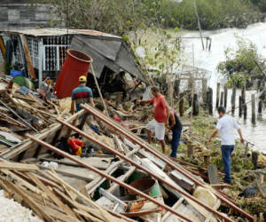 Cubans tries to recover belongings from a their destroyed house in Antillas population, Holguin province, 750km east of Havana, on October 26, 2012. Hurricane Sandy claimed 11 lives as it tore across Cuba Thursday, leaving a path of destruction in the eastern part of the island, officials in Havana said. AFP PHOTO/STR