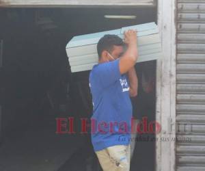 El padre del menor, muy acongojado recogió el pequeño féretro azul y lo subió a la paila de un vehículo. Foto: Alex Pérez / EL HERALDO.