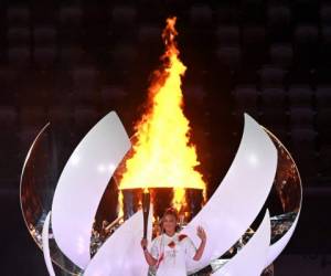 La tenista japonesa Naomi Osaka enciende el caldero olímpico con la llama olímpica durante la ceremonia de apertura de los Juegos Olímpicos de Tokio 2020, en el Estadio Olímpico, en Tokio, el 23 de julio de 2021. (Foto de Andrej ISAKOVIC / AFP)