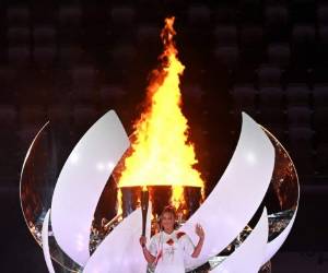 La tenista japonesa Naomi Osaka enciende el caldero olímpico con la llama olímpica durante la ceremonia de apertura de los Juegos Olímpicos de Tokio 2020, en el Estadio Olímpico, en Tokio, el 23 de julio de 2021. (Foto de Andrej ISAKOVIC / AFP)