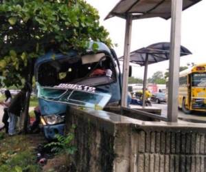 El autobús chocado y al fondo se observan personas brindado ayuda al hombre que finalmente murió debido a los golpes.