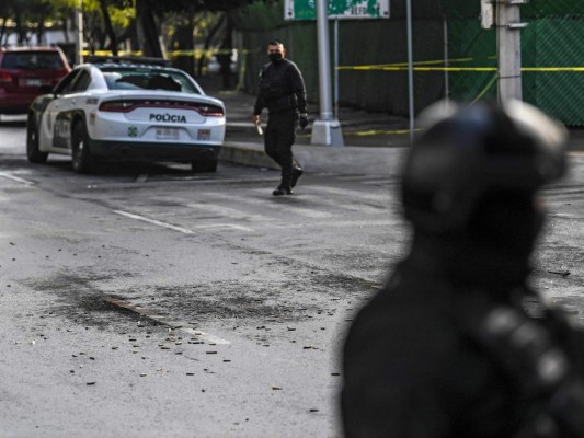 Se ven ataúdes de bala en el suelo cerca de los agentes de policía que custodian la escena del crimen después de que el Secretario de Seguridad Pública de la Ciudad de México, Omar García Harfuch, fuera herido en un ataque en la Ciudad de México. Foto: Agencia AFP.