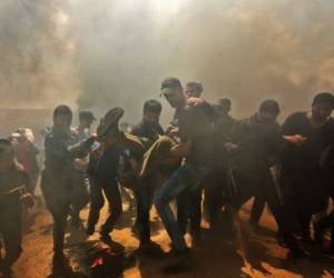 Palestinos llevan a un manifestante herido durante los enfrentamientos con las fuerzas israelíes cerca de la frontera entre la franja de Gaza e Israel al este de la ciudad de Gaza. Foto AFP