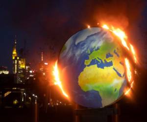Una maqueta del planeta Tierra arde ante la sede del Banco Central Europeo en Fráncfort, Alemania, el miércoles 21 de octubre de 2020. Activistas del llamado 'KoalaKollektiv', una organización que reclama justicia climática, quemó la maqueta en protesta por la política climática del BCE.
