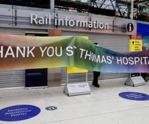 Personal de la estación ferroviaria Waterloo en Londres instala un cartel de agradecimiento al vecino hospital St. Thomas, Londres. Foto: AP.