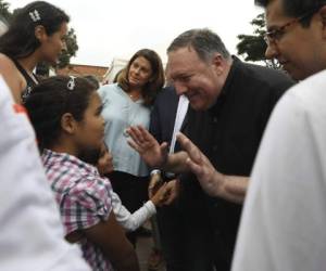 El secretario de Estado estadounidense Mike Pompeo saluda a una joven migrante venezolana en un refugio durante un recorrido acompañado de la vicepresidenta colombiana Marta Lucía Ramírez, al fondo, y el presidente de Colombia Iván Duque, quien no aparece en la imagen, en La Parada, cerca de Cúcuta, Colombia, el domingo 14 de abril de 2019.