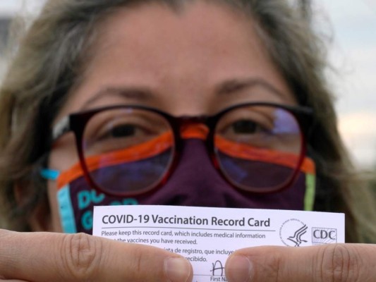 Alejandra, una dentista mexicana y que pidió no revelar su apellido, posa con su tarjeta de vacunación después de recibir la segunda dosis de la vacuna de Moderna contra el COVID-19. Foto: Agencia AP.