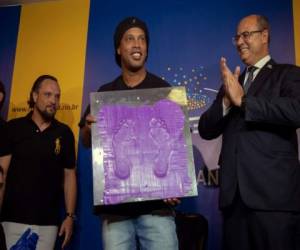 El jugador de fútbol brasileño Ronaldinho Gaucho muestra sus huellas durante una ceremonia en el Salón de la Fama del Estadio Maracaná, en Río de Janeiro, Brasil. Foto Agencia AFP.