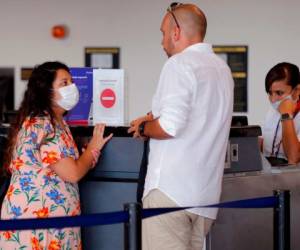 Los pasajeros usan mascarillas protectoras como precaución contra la propagación del nuevo Coronavirus, COVID-19, en el Aeropuerto Internacional Jorge Chávez, en Lima. AFP.