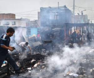 La gente trata de recuperar elementos de los escombros después de que se produjera un incendio al amanecer en el barrio de San Juan Bosco en la ciudad portuaria de Callao, cerca de Lima, Perú, el 25 de julio de 2019.