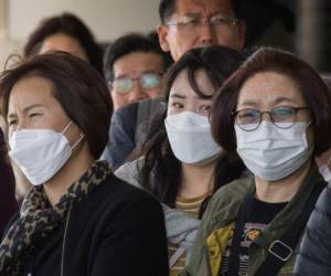 Los pasajeros usan máscaras faciales para protegerse contra la propagación del Coronavirus cuando llegan en un vuelo desde Asia al Aeropuerto Internacional de Los Ángeles. Foto Agencia AFP.