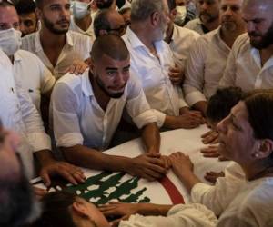 Parientes y amigos del bombero Ralph Malahi, de 23 años, muerto en la explosión del 4 de agosto que arrasó el puerto de Beirut, asisten a su funeral, sábado 15 de agosto de 2020.
