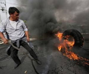 Un hombre quema un neumático durante una protesta contra la eliminación de los subsidios al combustible anunciada por el presidente Lenín Moreno, en Quito, Ecuador, el jueves 3 de octubre de 2019. Foto: AP.
