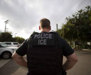 Un oficial de inmigración observa durante un operativo en Escondido, California. Foto: AP.