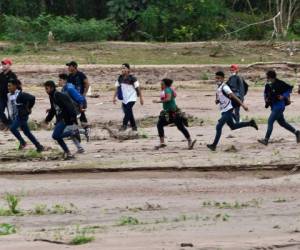 Migrantes que se dirigen a la frontera con Guatemala en su camino a Estados Unidos, cruzan el cauce seco del río Copán en el municipio de Santa Rita, en el departamento hondureño de Copán, el 15 de enero de 2021. Foto: AFP