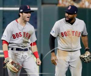 Andrew Benintendi (izquierda) festeja con Jackie Bradley Jr., tras realizar una atrapada que sifgnificó el triunfo de los Medias Rojas de Boston sobre los Astros de Houston.