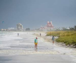 Unas personas caminan por la playa Pass-a-Grille tras el paso de la tormenta Elsa en Tampa Bay, Florida, el 7 de julio de 2021. (Martha Asencio-Rhine/Tampa Bay Times via AP).