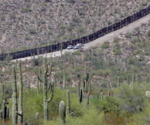 Agentes de la Oficina de Aduanas y Protección Fronteriza recorren una sección del muro fronterizo internacional que atraviesa el Monumento Nacional Organ Pipe, en Lukeville, Arizona. Foto AP