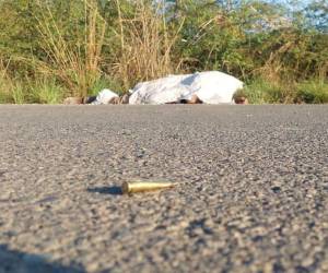 El cuerpo de una de las víctimas quedó tendido en el pavimento, mientras el otro individuo quedó ensangrentado a bordo del vehículo.