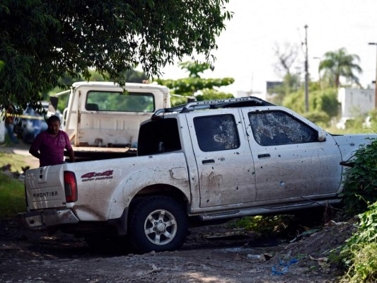 Un hombre se para al lado de un camión con agujeros de bala después de que hombres armados fuertemente armados libraron una batalla total contra las fuerzas de seguridad mexicanas en Culiacán, estado de Sinaloa, México.