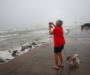 Cheri Daigle, una profesora jubilada, toma una fotografía mientras el huracán Nicholas se acerca a la costa de Texas, el lunes 13 de septiembre de 2021. FOTO: AP