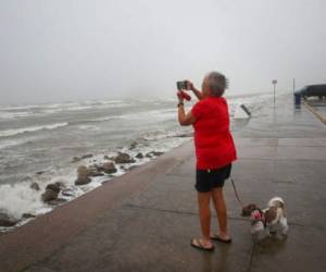 Cheri Daigle, una profesora jubilada, toma una fotografía mientras el huracán Nicholas se acerca a la costa de Texas, el lunes 13 de septiembre de 2021. FOTO: AP