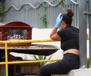 A woman wearing a face mask and gloves mourns as she waits for the corpse of a relative outside a hospital in Guayaquil, Ecuador on April 1, 2020. - Residents of Guayaquil, in Ecuador's southwest, express outrage over the way the government has responded to the numerous deaths related to the novel coronavirus, COVID-19, saying there are many more deaths than are being reported and that bodies are being left in homes for days without being picked up. Ecuador marked its highest daily increase in deaths and new cases of coronavirus on Sunday, with the total reaching 14 dead and 789 infected, authorities had said. (Photo by Enrique Ortiz / AFP)