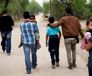 En esta fotografía de archivo del 14 de marzo de 2019, un grupo de familias migrantes recorre un camino poco antes de que la Patrulla Fronteriza lo detuviera cerca de McAllen, Texas.