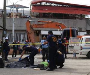 Los socorristas sacaron los cuerpos de dos víctimas del edificio que albergaba un mercado que se hundió en la ciudad de Padada. Foto: AFP